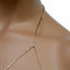 A close up of a rhinestone strap of rhinestone gem body chain halter top bralette with a clear gem in the middle.