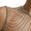 A close up of a mannequin wearing a silver draped shoulder body chain against a white backdrop.