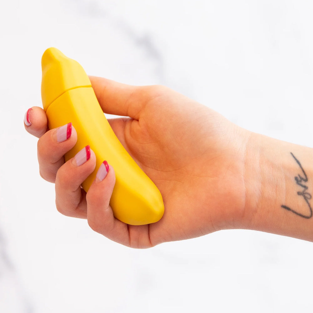 Emojibator Banana Emoji Curved Silicone Mini Vibrator has 10 vibration modes packed into a curved body shaped like a fun banana emoji to make me-time more appealing. On-hand.