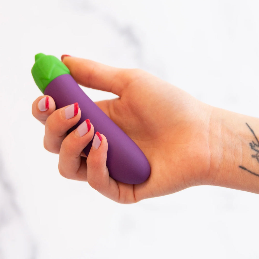 Emojibator Eggplant Emoji Silicone Mini Vibrator has 10 vibration modes packed into a bulbous body shaped like the iconic eggplant emoji to enhance self-pleasure. On-hand.