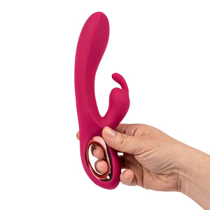 A hand holds a pink rabbit vibrator with hollow handle highlighting the ergonomic shape on a white background