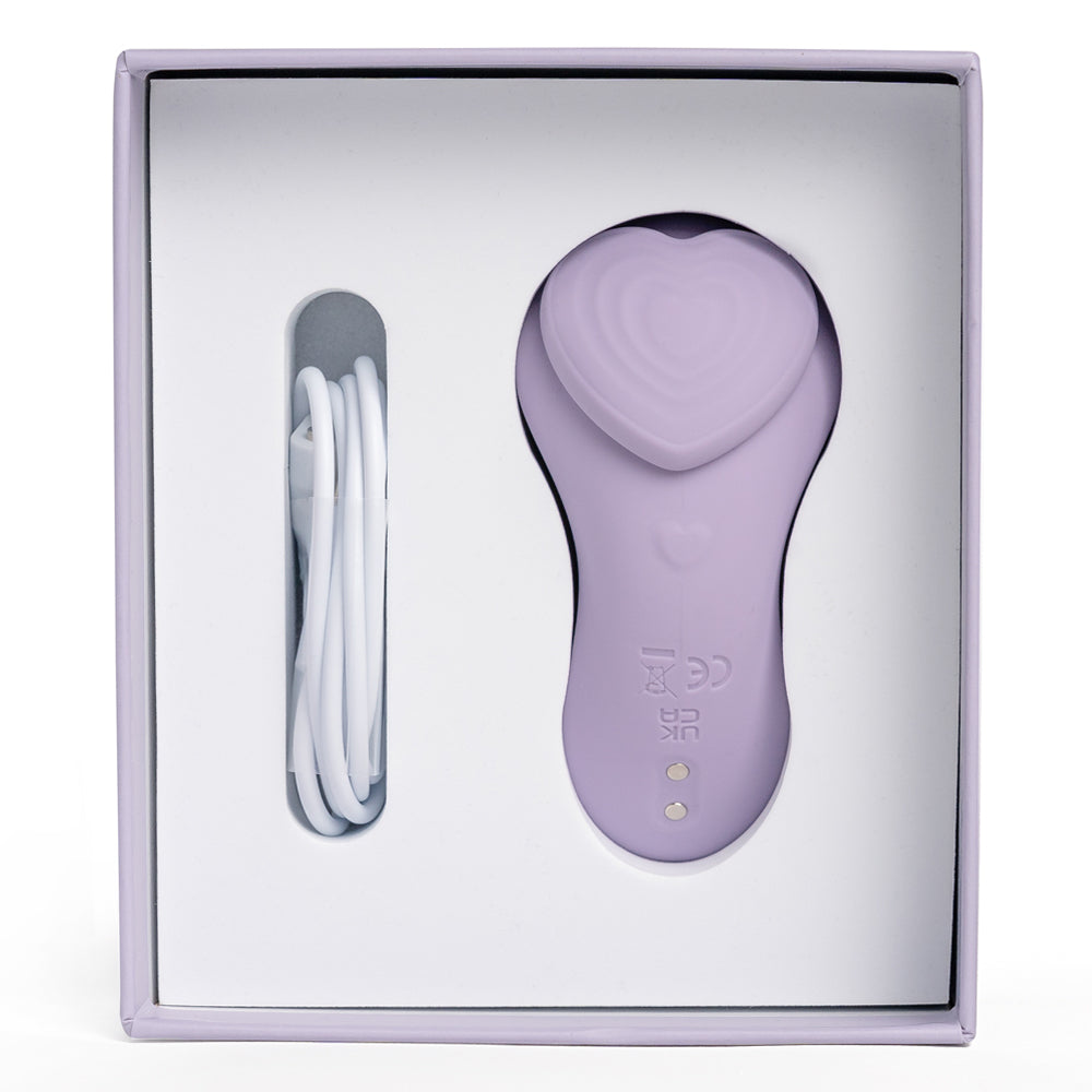 Front view of Winyi's My Love heart-shaped panty vibrator inside its packaging with the charging cord next to it.