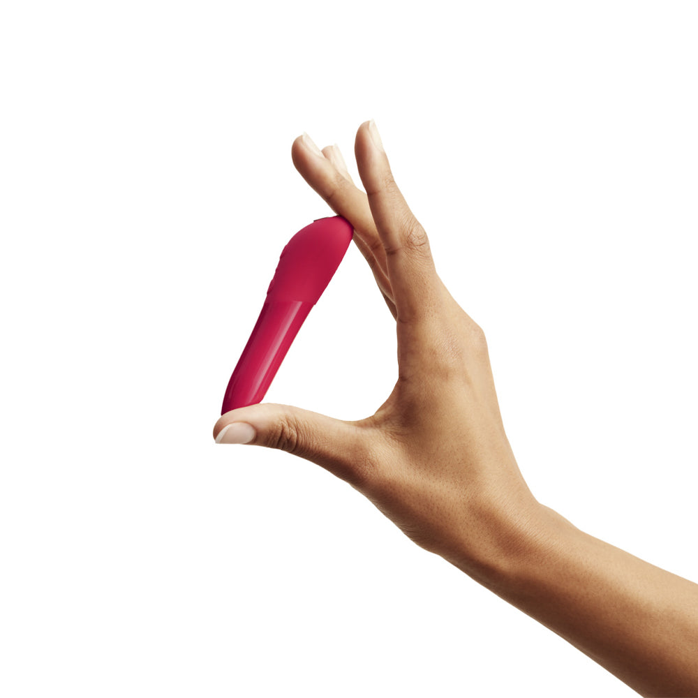 Hand Holding We-Vibe Tango X Bullet Vibrator Waterproof Sex Toy With Silicone Grip & Magnetic USB Recharging in Cherry Red