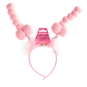 A pink headband with two springs coming from the top and penises made of pompoms on top of each spring.