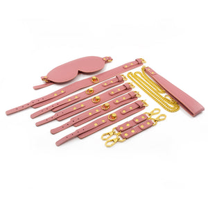 Sevanda 5-Piece Pink Bondage Set includes 4 wrist/ankle cuffs, a collar w/ chain leash + a blindfold & is made from vegan pink faux leather + luxurious gold metal.